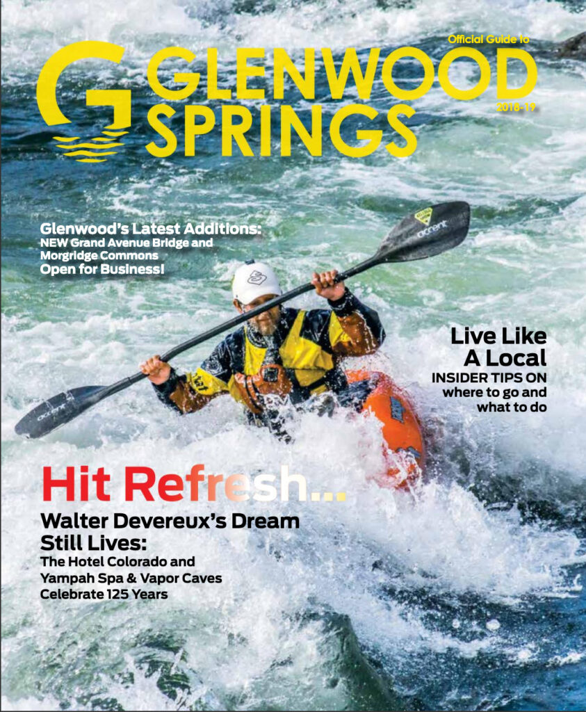 Kayaker on a wave with a smile on his face, dressed in water gear with vest and helmet, holding a paddle in his hand, the background is wavesr moving in all directions in multi colors of blue